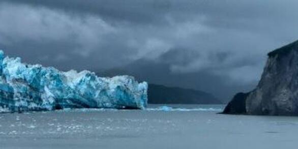 Panorama of Alaskan coastline with Hubbard Glacier on the left and hills on the right