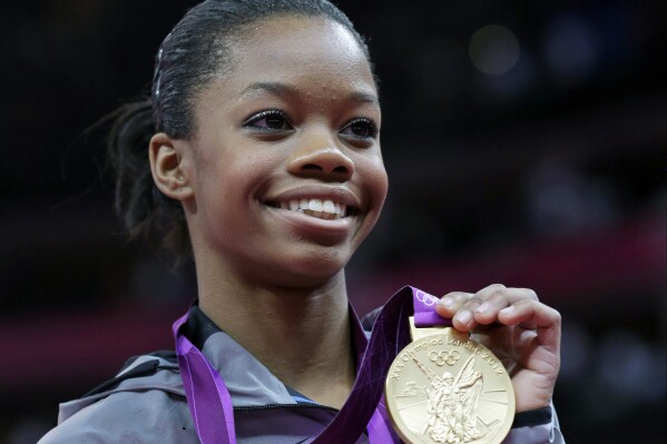 FILE - U.S. gymnast Gabby Douglas displays her gold medal during the artistic gymnastics women's individual all-around competition at the 2012 Summer Olympics in London, Aug. 2, 2012. Douglas pulled out of this weekend's 2024 Winter Cup in Louisville after testing positive for COVID-19. The meet was to be Douglas' first competition since the 2016 Olympics (AP Photo/Julie Jacobson, File)