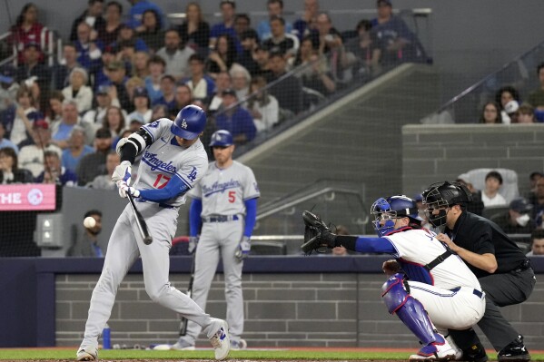 Los Angeles Dodgers' Shohei Ohtani (17) hits a single during the first inning of a baseball game against the Blue Jays in Toronto, Saturday, April 27, 2024. (Chris Young/The Canadian Press via AP)