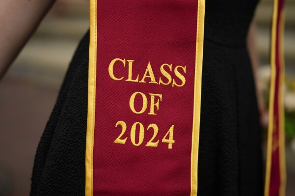 A recent graduate wears a garment with their graduation year on the University of Southern California campus Thursday, April 25, 2024, in Los Angeles. The University of Southern California canceled its main graduation ceremony Thursday. College officials across the U.S. are worried the ongoing Israel-Hamas war protests could disrupt plans for commencement ceremonies next month. (AP Photo/Jae C. Hong)