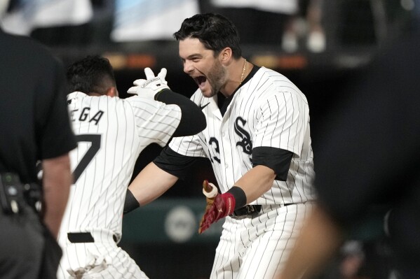 Chicago White Sox's Andrew Benintendi, right, begins to celebrate after his winning two-run home run off Tampa Bay Rays relief pitcher Phil Maton to end a 10-inning baseball game Saturday, April 27, 2024, in Chicago. (AP Photo/Charles Rex Arbogast)