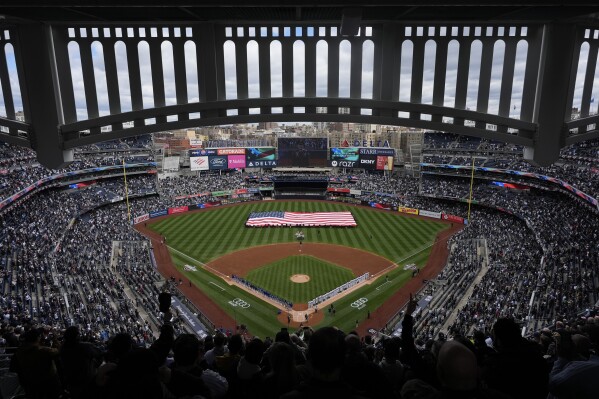 A giant American flag is unfurled before the start of the home-opener baseball game at Yankee Stadium between the New York Yankees and the Toronto Blue Jays, Friday, April 5, 2024, in New York. (AP Photo/Seth Wenig)