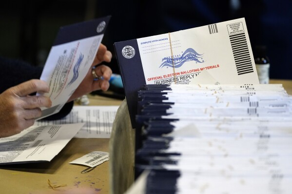 FILE - Chester County, Pa. election workers process mail-in and absentee ballots at West Chester University in West Chester on Nov. 4, 2020. A form Pennsylvania voters must complete on the outside of the envelopes used to return mail-in ballots has been redesigned, but that did not keep some voters from failing to complete it accurately for this week's primary, election officials said. Some votes will not count as a result. (AP Photo/Matt Slocum, File)