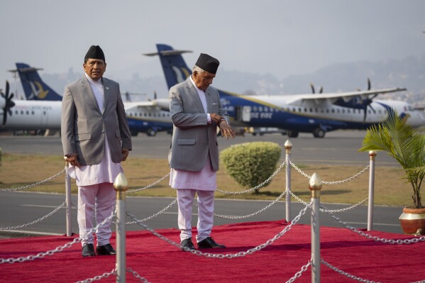 Nepal's President Ram Chandra Poudel checks his watch as he and Minister of Foreign Affairs Narayan Kaji Shrestha, wait for Qatar's Emir Sheikh Tamim bin Hamad Al arrival at Tribhuvan international airport in Kathmandu, Nepal, Tuesday, April 23, 2024. The emir arrived on a two-days visit to the Himalayan nation. (AP Photo/Niranjan Shreshta)