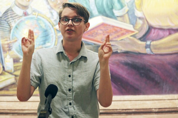 Isaac Johnson, who just completed an internship with Topeka's public schools and is finishing work on a social work degree, talks to reporters during a news conference, Thursday, April 26, 2024, in front of a mural at the Statehouse in Topeka, Kan. Johnson, who is transgender, worries about the effects of a proposed ban on gender-affirming care for minors, which also would bar state employees from promoting social transitioning for youth. (AP Photo/John Hanna)