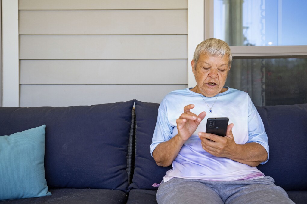 Sheri Wilkins talks about her experience using the DailyPay app outside of the clubhouse at her apartment complex in College Station, Texas on Tuesday, March 26, 2024. (AP Photo/Sam Craft)