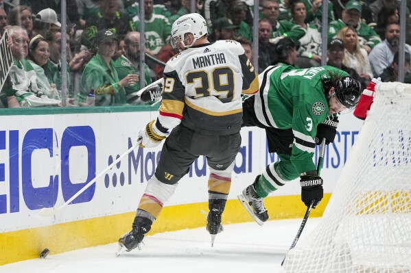 Vegas Golden Knights right wing Anthony Mantha (39) and Dallas Stars defenseman Chris Tanev (3) compete for possession of the puck during the second period in Game 2 of an NHL hockey Stanley Cup first-round playoff series in Dallas, Wednesday, April 24, 2024. (AP Photo/Tony Gutierrez)