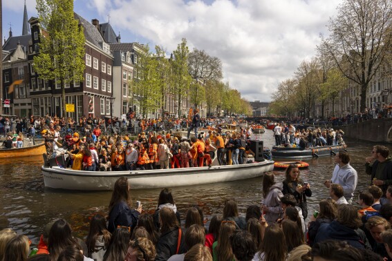 People dance on a boat during King's Day celebrations in Amsterdam, Netherlands, Saturday, April 27, 2024. (AP Photo/Peter Dejong)