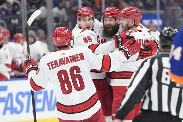 Carolina Hurricanes' Brent Burns, second from right, celebrates with Jaccob Slavin, right, Teuvo Teravainen (86) and Martin Necas (88) after scoring a goal against the. New York Islanders during the first period of Game 3 of an NHL hockey Stanley Cup first-round playoff series Thursday, April 25, 2024, in Elmont, N.Y. (AP Photo/Frank Franklin II)