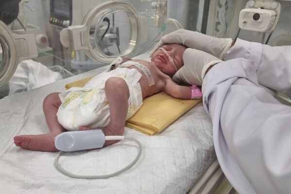 FILE - A Palestinian baby girl, Sabreen Jouda, who was delivered prematurely after her mother was killed in an Israeli strike along with her husband and daughter, lies in an incubator in the Emirati hospital in Rafah, southern Gaza Strip. Sunday, April 21, 2024. A premature Palestinian infant, rescued from her mother's womb shortly after the woman was killed in an Israeli airstrike, has died, her uncle said Friday, April 26, 2024. (AP Photo/Mohammad Jahjouh, File)