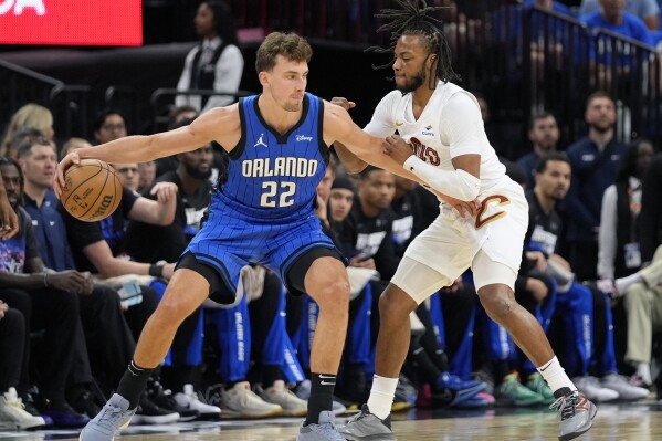 Orlando Magic forward Franz Wagner (22) makes a move against Cleveland Cavaliers guard Darius Garland, right, during the first half of Game 4 of an NBA basketball first-round playoff series, Saturday, April 27, 2024, in Orlando, Fla. (AP Photo/John Raoux)