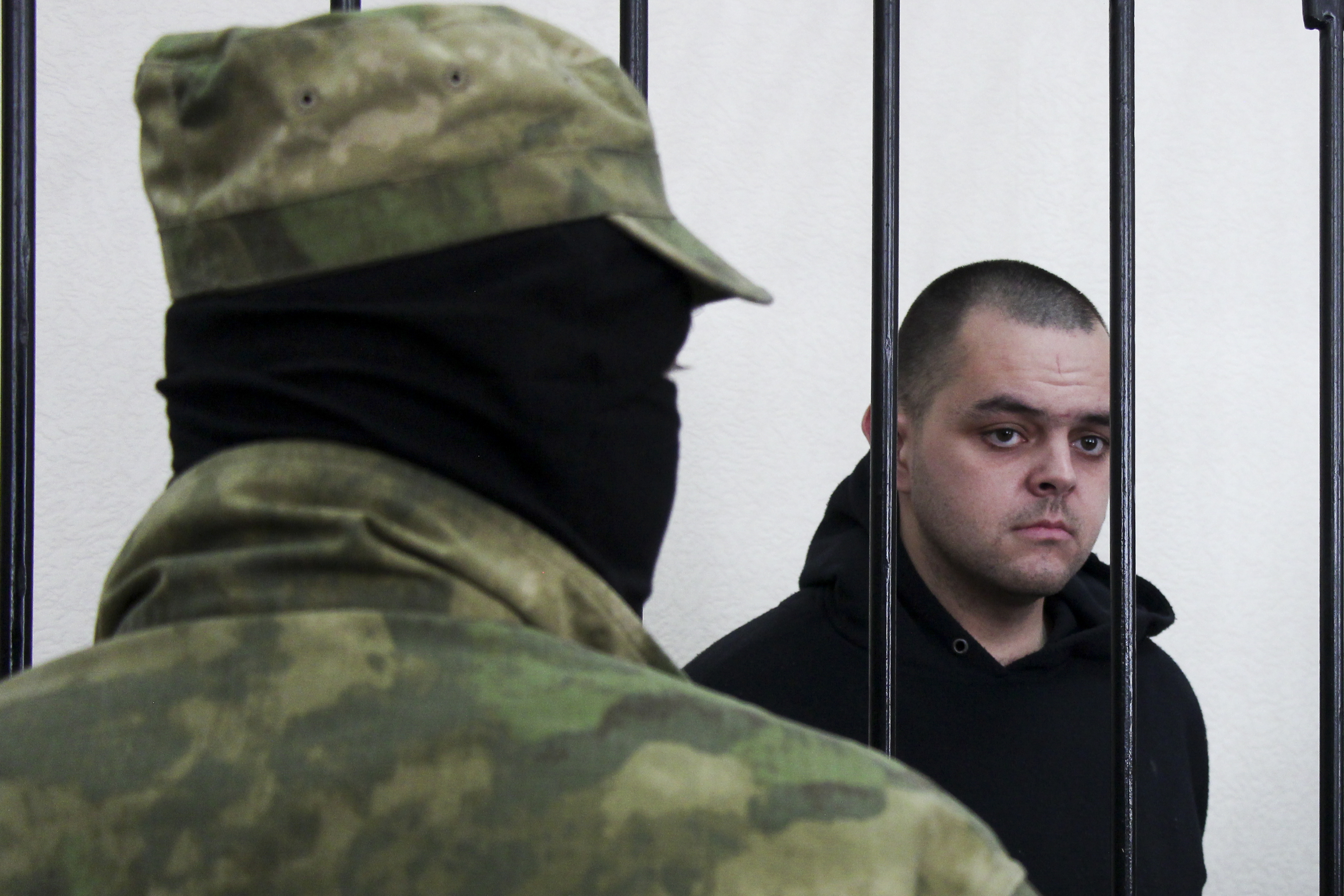 British citizen Aiden Aslin stands behind bars in a courtroom in Donetsk People's Republic (DPR) on June 9.