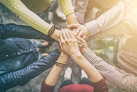 a group of people with their hands forming a circle