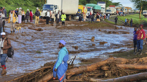 Des habitants autour d'une route inondée, le 29 avril 2024, dans la ville de Mai Mahiu, dans le comté de Nakuru, à une centaine de kilomètres au nord-ouest de Nairobi au Kenya.