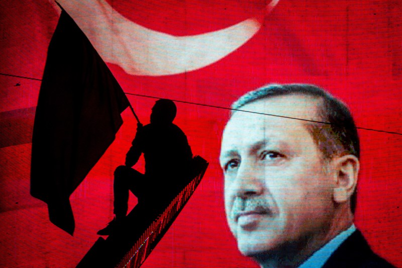 A supporter of Turkish President Recep Tayyip Erdogan waves a flag against an electronic billboard during a rally in Ankara on July 18, 2016.(Chris McGrath/Getty Images)