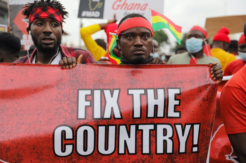 A Ghanian protester holds a banner.