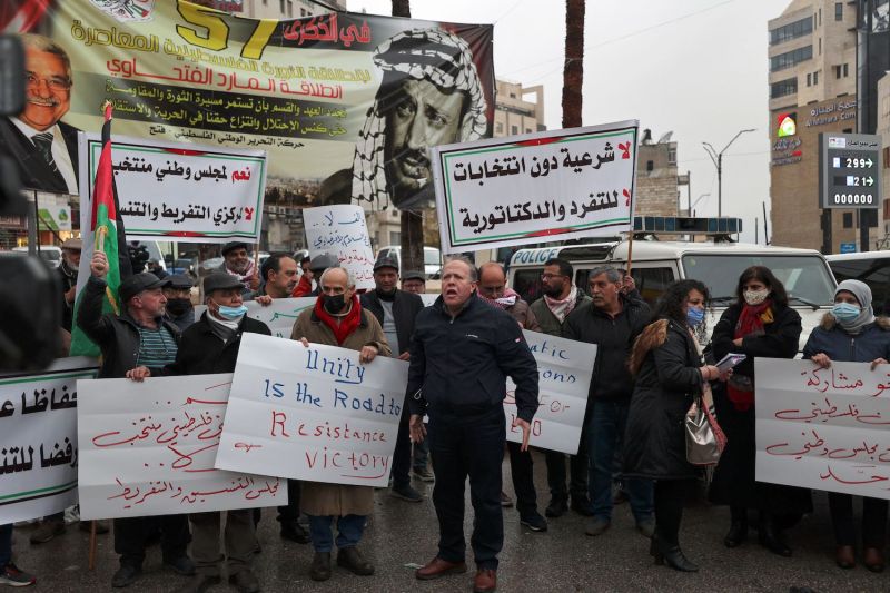 Palestinians lift placards as they protest the meeting of the Palestine Liberation Organization’s Central Committee in Ramallah, West Bank, on Feb. 6.