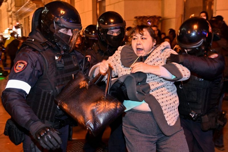 Police officers detain a woman during a protest against military mobilization in Moscow on Sept. 21.
