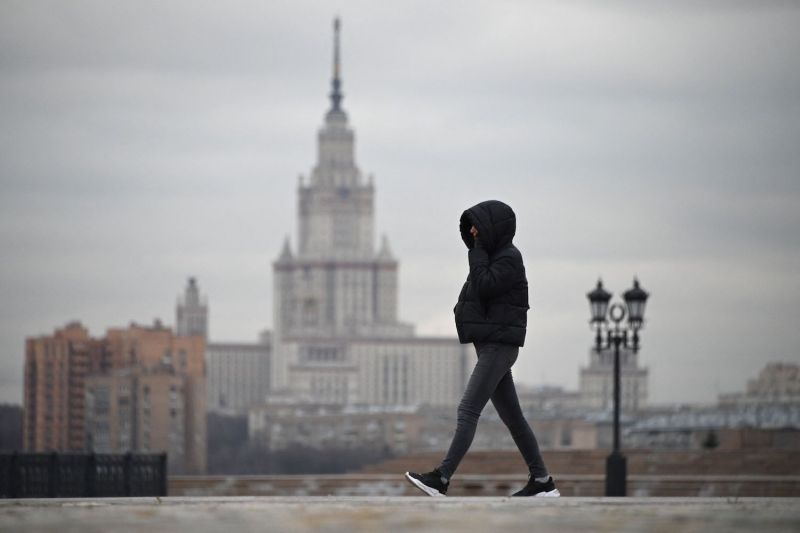 A woman walks at the Poklonnaya Hill war memorial near the main building of Moscow State University in Moscow.