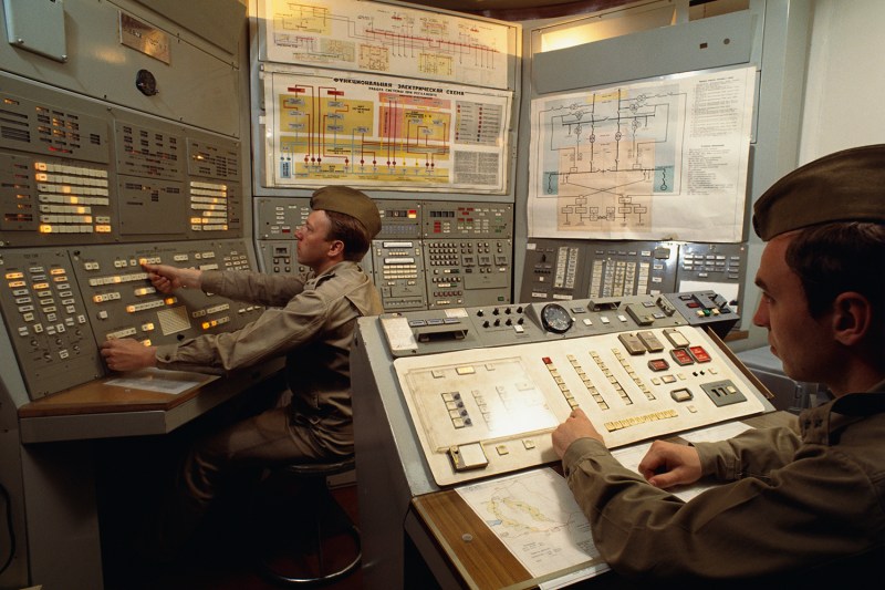 Two men sit at control boards inside the control room at a nuclear missile base outside Moscow.