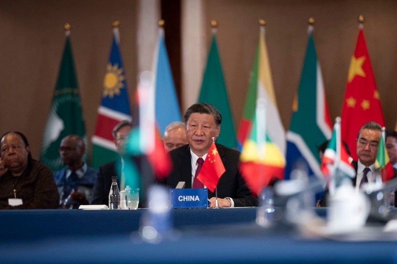 Chinese President Xi Jinping, surrounded by flags of African countries, gestures as he speaks at the China-Africa Leaders' Roundtable Dialogue during the BRICS summit in Johannesburg.