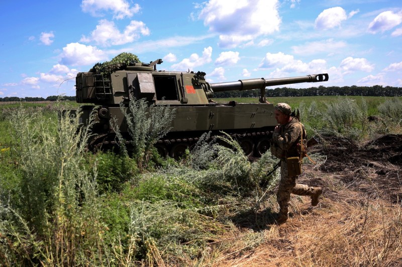 A Ukrainian marine from the 37th Brigade walks past an M109 155 mm self-propelled howitzer at a position in the Donetsk region on July 10, 2023.