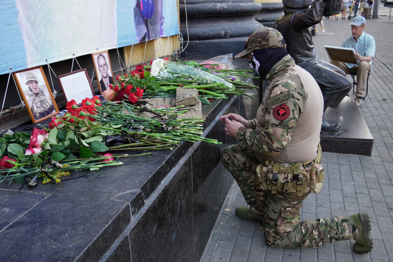A Wagner fighter pays tribute to Yevgeny Prigozhin and Dmitry Utkin at a makeshift memorial in Rostov-on-Don, Russia.