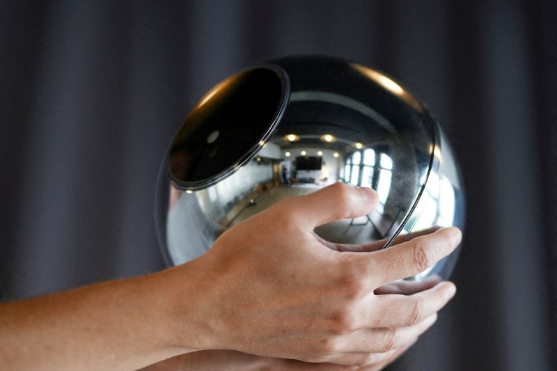 Hands hold  the Orb, a biometric imaging device for Worldcoin, which aims to create a World ID digital passport with a tradeable cryptocurrency, in Berlin on Aug. 1. Annegret Hilse/Reuters