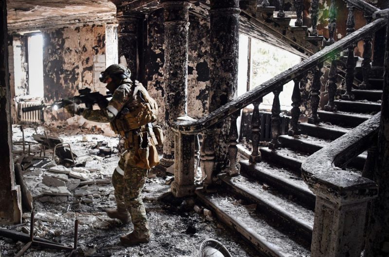 A Russian soldier patrols the Mariupol drama theater, bombed by Russia when it housed civilian refugees, in Mariupol, Ukraine, on April 12, 2022.