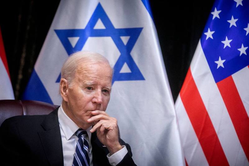 A closeup photo of Biden sitting in front of Israeli and U.S. flags looking contemplative. Netanyahu is not seen in the frame.