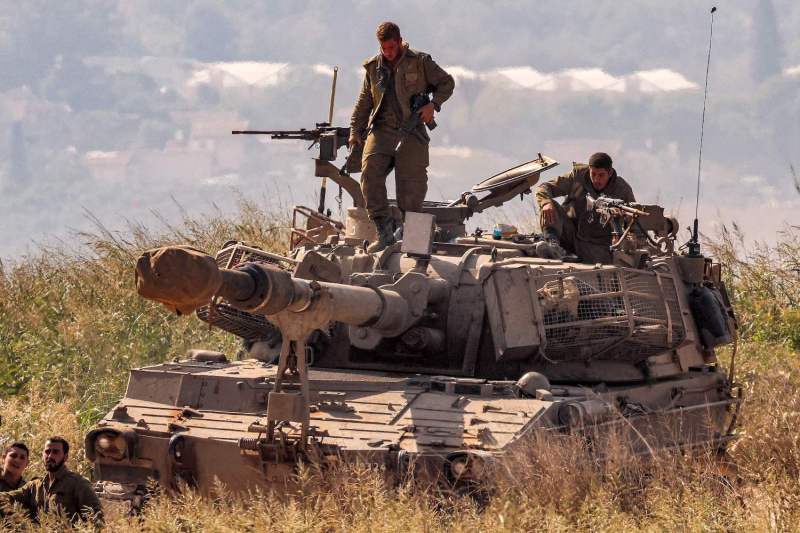 An Israeli army soldier stands next to a machine gun turret atop a howitzer near the border with the Gaza Strip in southern Israel.