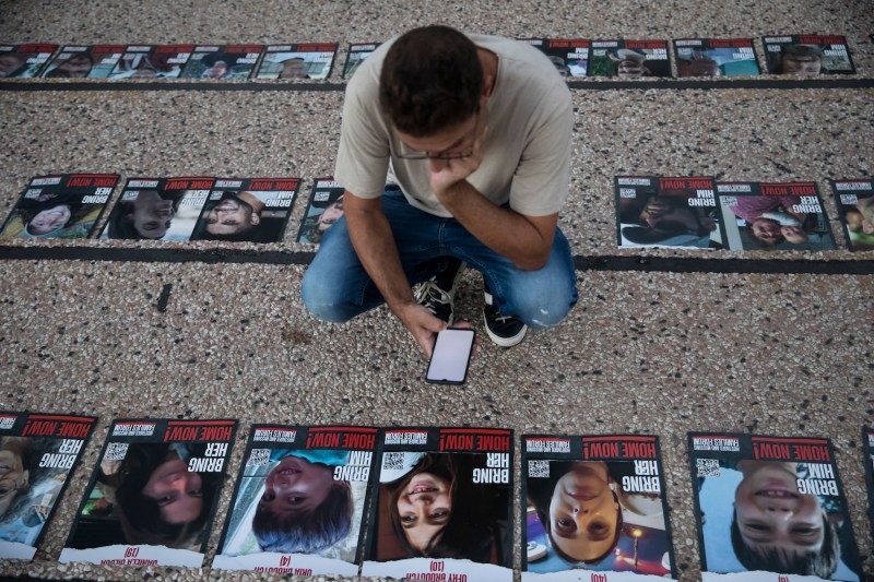 People look at photos of hostages that were kidnapped by Hamas.
