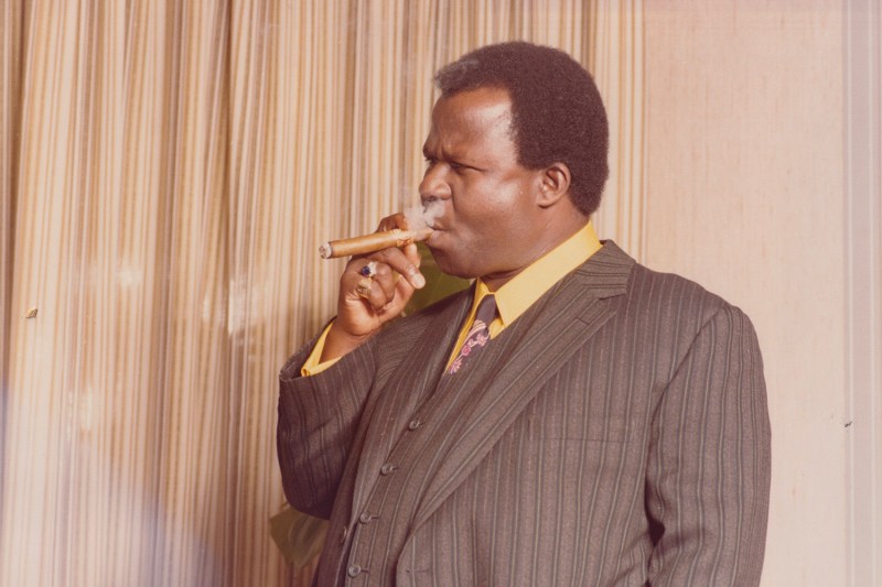 John Ackah Blay-Miezah smokes a cigar in the London office of the Oman Ghana Trust Fund in the 1980s.