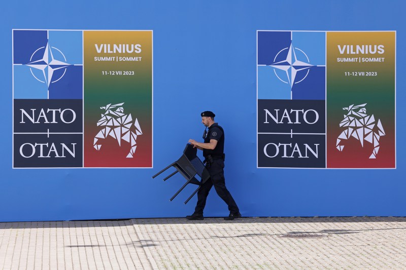 A security guard moves a chair at the NATO summit venue