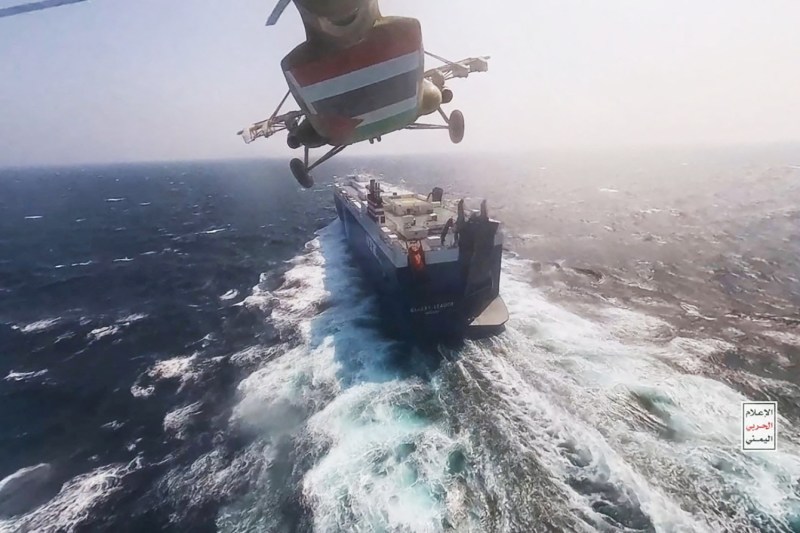 In a photo released by the Houthi military on Nov. 20, a Houthi helicopter flies over the Galaxy Leader cargo ship in the Red Sea.