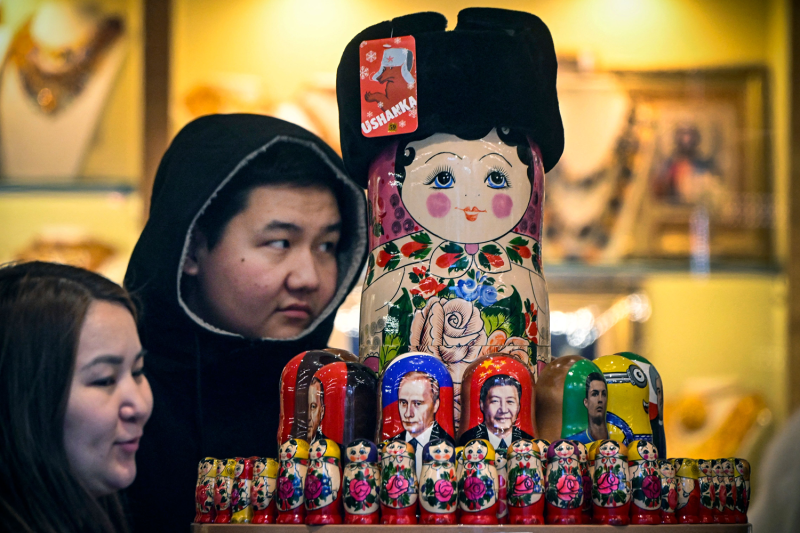 Tourists inspect Russian wooden dolls showing  Chinese President Xi Jinping and his Russian counterpart, President Vladimir Putin, in downtown Moscow on Nov. 15, 2023.