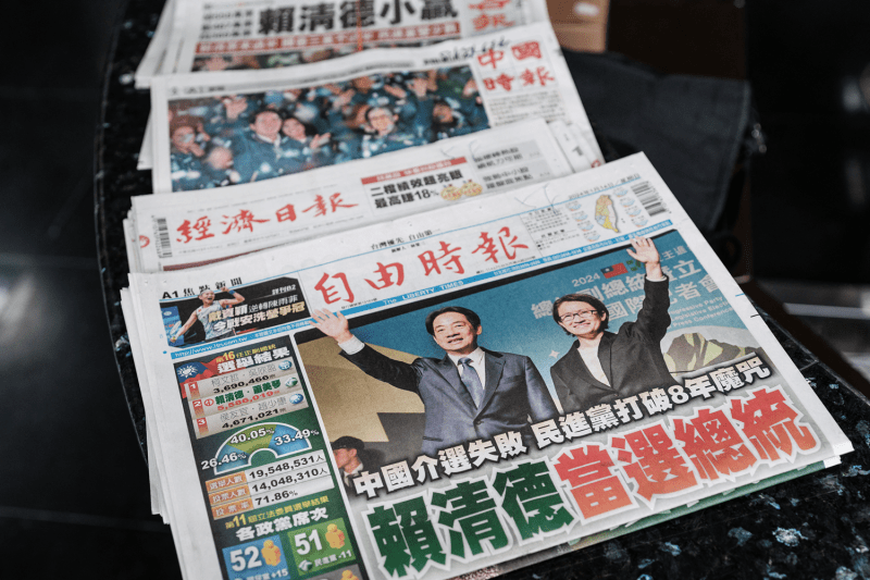 Local Taiwanese newspapers featuring the presidential election results on the front pages rest on a counter in an office building in Taipei.