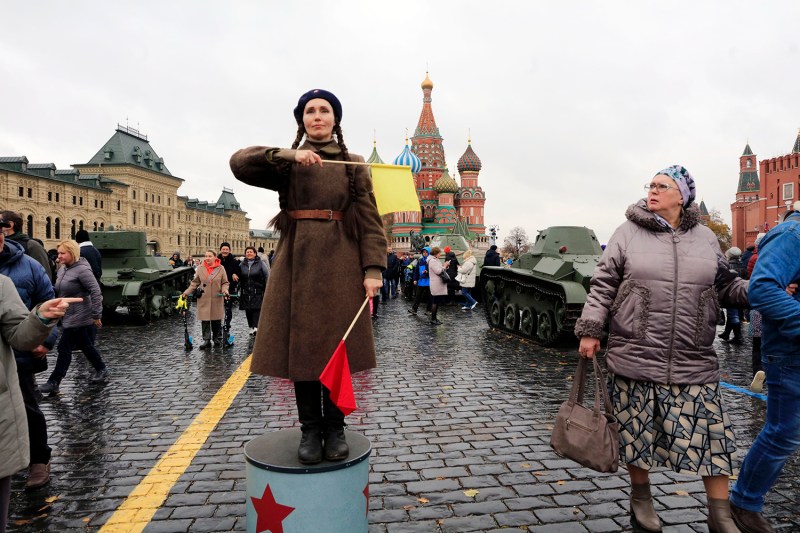 A woman wearing a Soviet military uniform directs pedestrians during an exhibition of Soviet tanks and military vehicles at Red Square in Moscow.