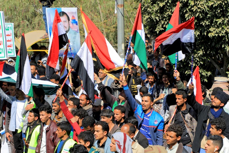 People wave Palestinian and Yemeni flags as they chant anti-Israel and anti-U.S. slogans in Yemen.