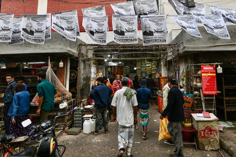 People walk past election posters in a market in Dhaka, Bangladesh.