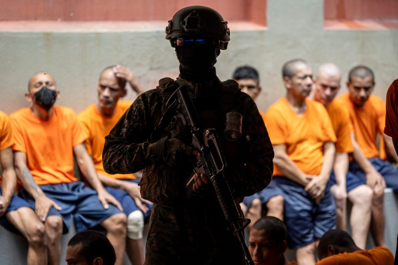 An Ecuadorian soldier stands guard over inmates at Litoral Penitentiary—the country’s largest prison—during a media visit in Guayaquil, Ecuador on Feb. 9.