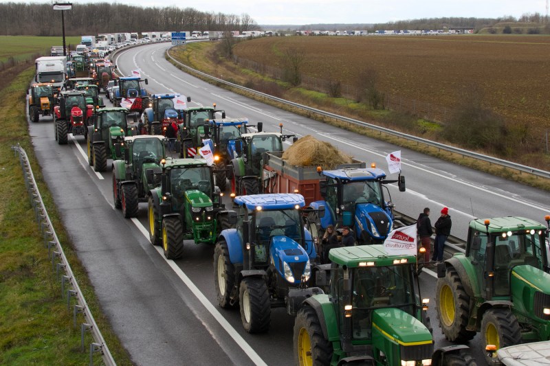 French farmers drive their tractors on the A71 highway in protest.