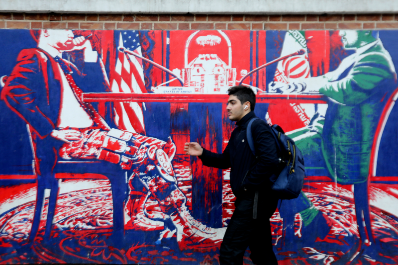 A young man walks past anti-U.S. graffiti outside the building that formerly hosted the U.S. Embassy in Tehran.
