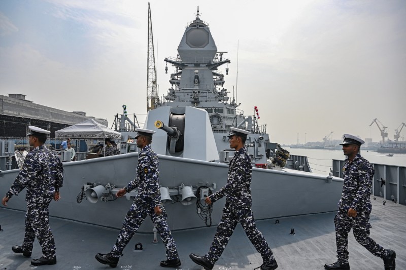 Sailors walk on the deck of the INS Imphal (Yard 12706), the third stealth guided missile destroyer of Project 15B, ahead of its commissioning into the Indian Navy, at the Naval Dockyard in Mumbai.