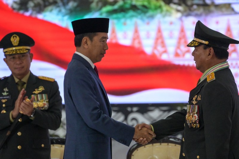 Indonesian President Joko Widodo shakes hands with Defense Minister Prabowo Subianto during a meeting with high-ranking military and police officers in Jakarta on Feb. 28.