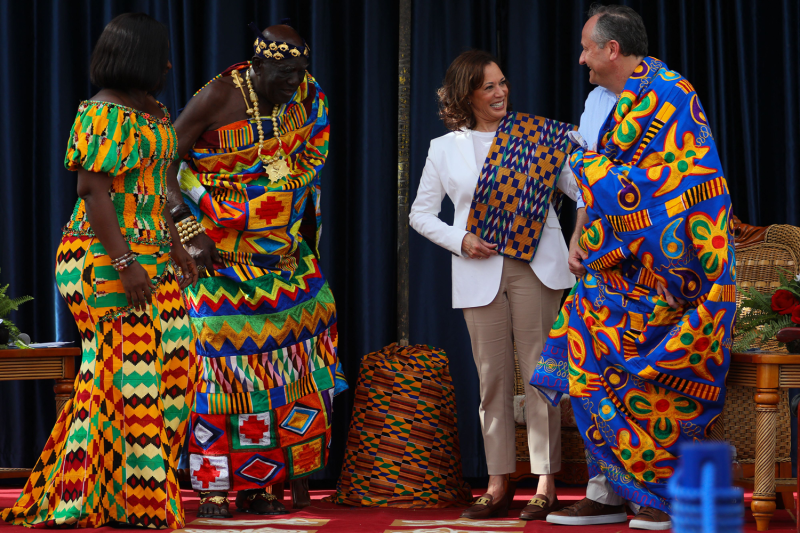 Chief Osabarima Kwesi Atta II (left) looks on as U.S. Vice President Kamala Harris reacts after receiving traditional Kente cloths at the Emintsimadze Palace in Cape Coast, Ghana, on March 28, 2023.