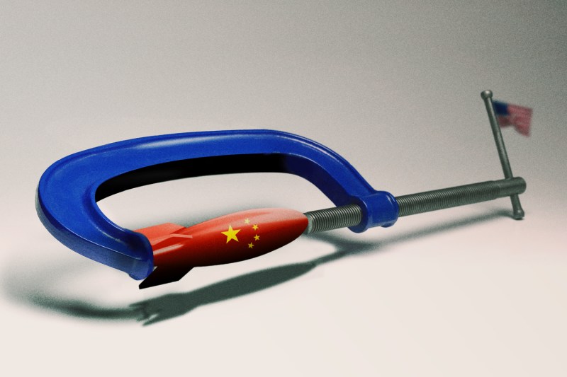 A blue vise with a U.S. flag for a pin holds a red missile with the stars of the China flag in its grip.