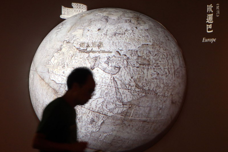 A man walks in front of an animated map of the world at an exhibition at the Hong Kong Science Museum.