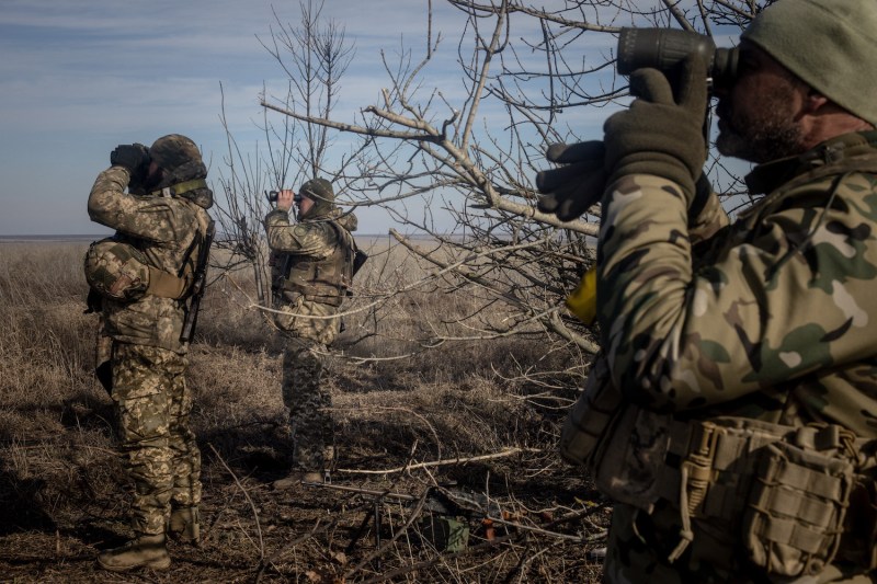 Members of Ukraine’s 72nd Brigade anti-air unit use binoculars to search for Russian drones near Marinka, Ukraine, on Feb. 23.