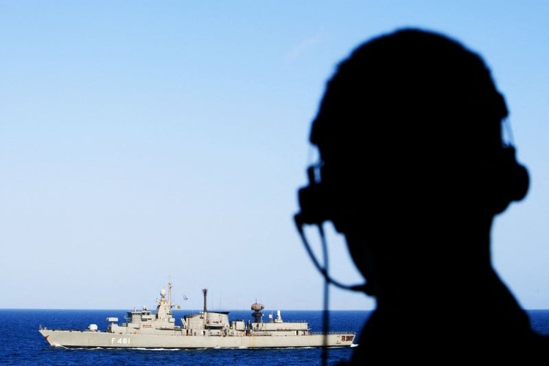 A crew member from the Dutch frigate HNLMS Evertsen looks at sea as his vessel receives a component from the Navarinon (F-461) of the Greek navy, in the Indian Ocean.